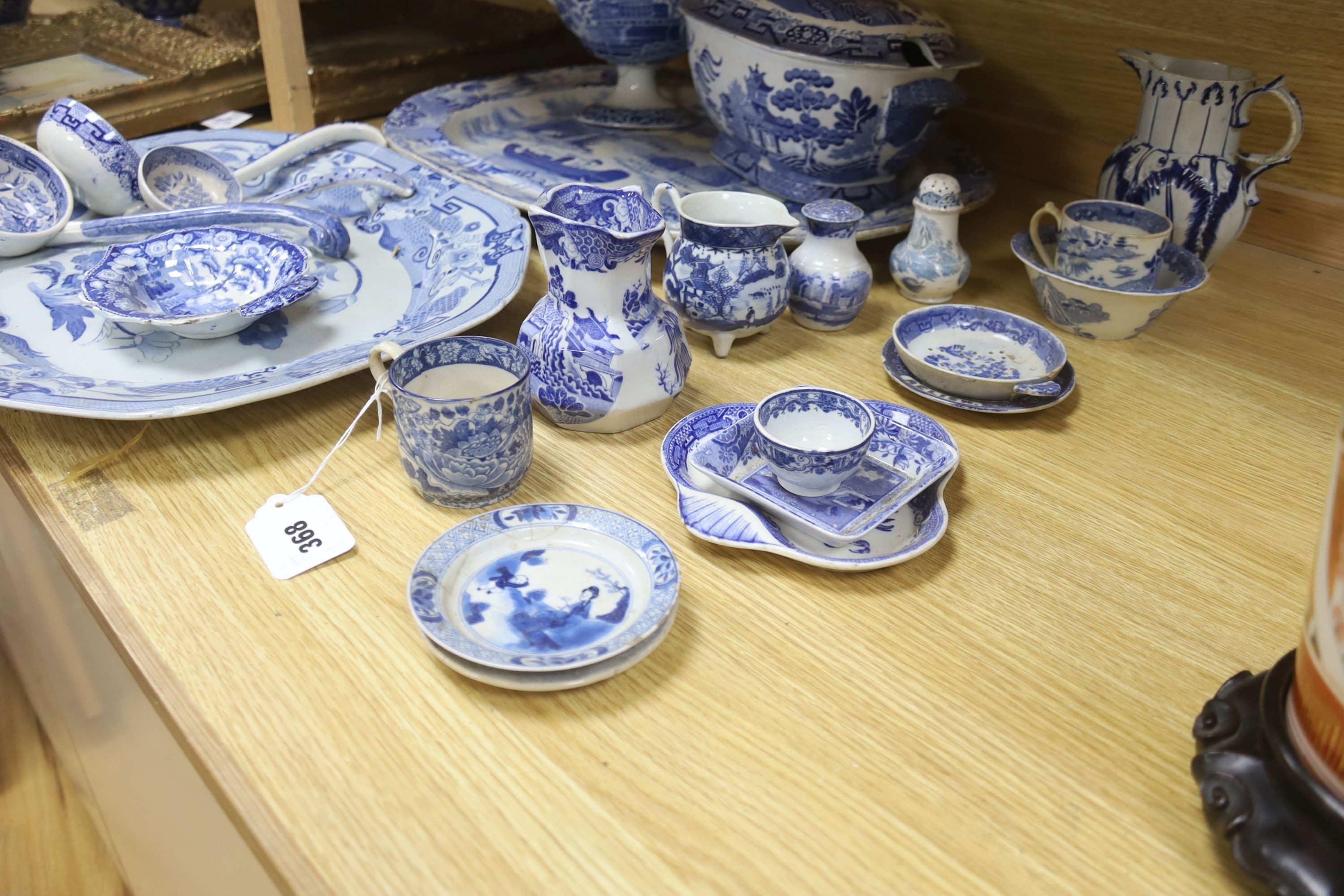 A group of 19th century blue and white pottery to include a chinoiserie pattern meat plate, 53.5 cm, a patent ironstone pheasant pattern dish, 47.5 cm, various tureens, dishes, ladles etc. a pearlware jug and two Chinese